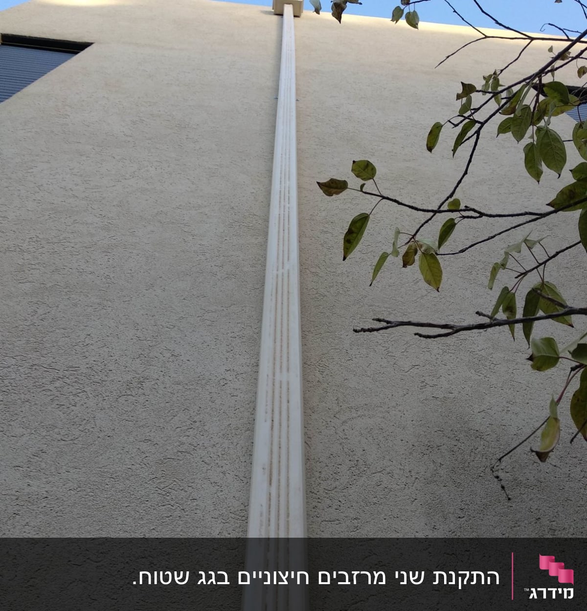 מרזב לבן מחובר לגג בניין
